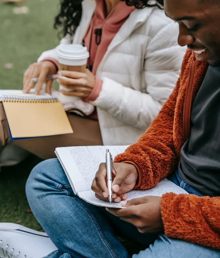 Students taking notes together outdoors
